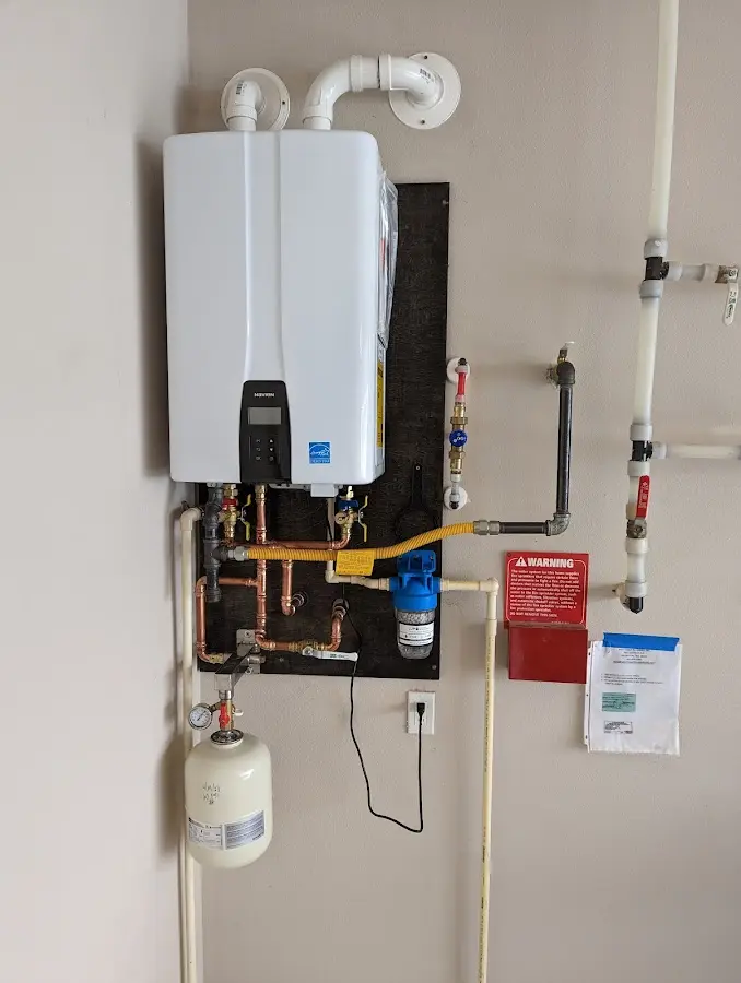 Professional plumber installing copper piping in a Manteno home